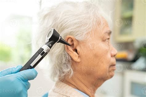 Audiologist Or Ent Doctor Use Otoscope Checking Ear Of Asian Senior