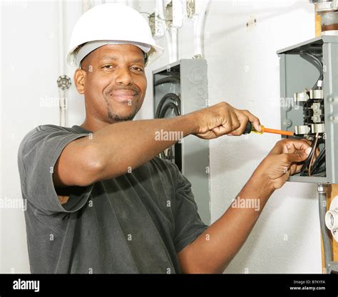 Handsome African American Electrician Working On A Breaker Panel Model