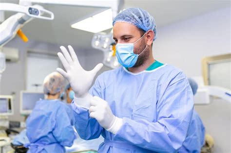 Portrait d un médecin chirurgien portant des gants médicaux debout dans