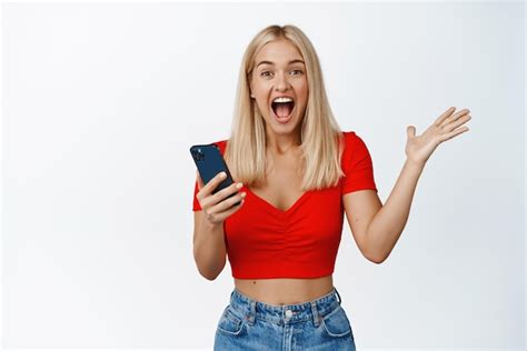 Une Fille Blonde Excit E R Agit La Notification Du T L Phone Portable Tenant Un Smartphone Et