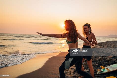 Preparation For Surfing A Young Woman Shows Her Best Friend How To Keep