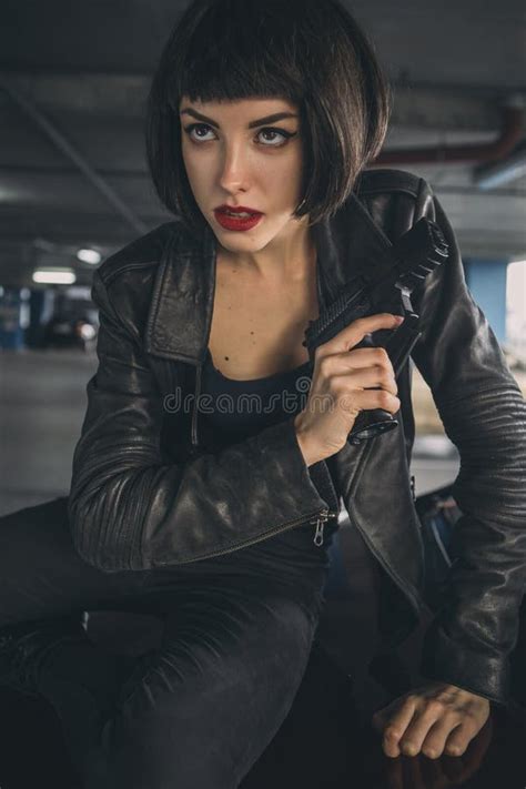 Beautiful Brunette Spy Agent Killer Or Police Woman In Leather Jacket And Jeans With A Gun In