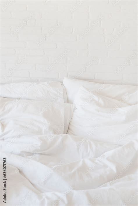 white bed sheets and pillows and white brick wall Stock Photo | Adobe Stock