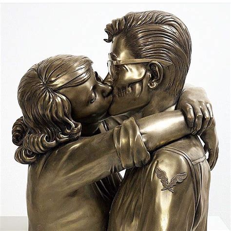 A Bronze Statue Of Two People Hugging Each Other