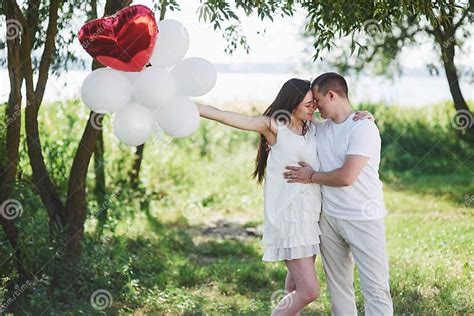 Happy And Young Pregnant Couple Hugging In Nature Romantic Moments