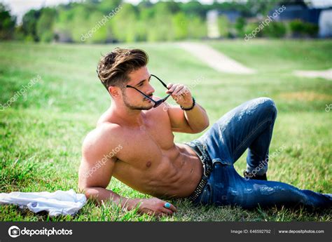 Good Looking Shirtless Fit Male Model Relaxing Lying Grass Shot Stock