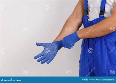 The Male Hands Of A Worker In Uniform Wearing Construction Gloves