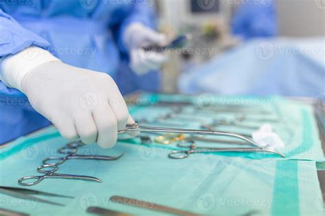 Operating Room Of Surgical Table With Instruments Assistant Picks Up