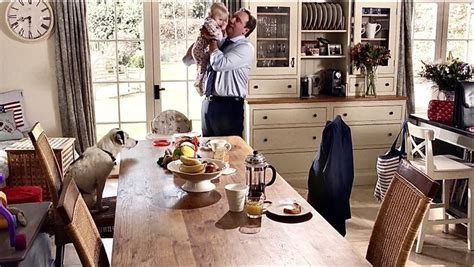 A Man Standing In A Kitchen Next To A Table With Food And Drinks On It