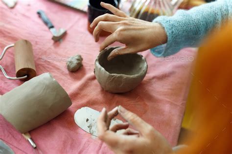 Womens Hands Knead The Clay And Sculpt A Cup Or Bowl From It The