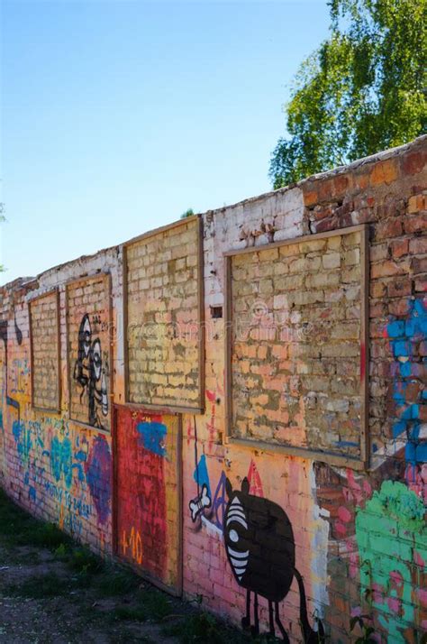 Toma Vertical De Una Colorida Pared De Ladrillo Con Cuadros De Arte En