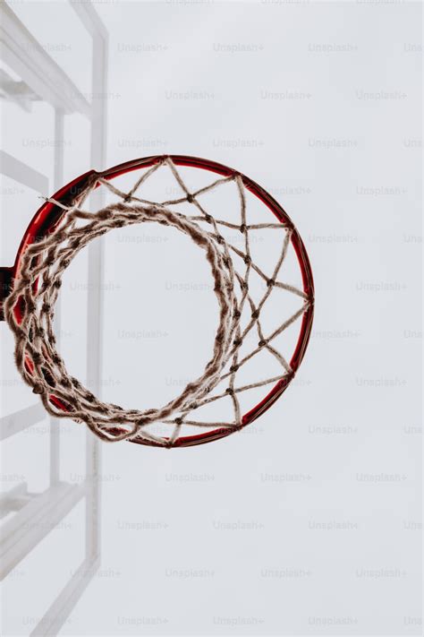 A basketball going through the rim of a basketball hoop photo ...