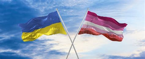 Two Crossed Flags Lesbian Pride And Ukraine Waving In Wind At Cloudy