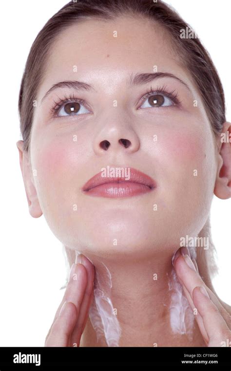 Female Brunette Hair Off Face Rubbing Moisturiser Into Both Sides Of Neck Fingertips Of Both