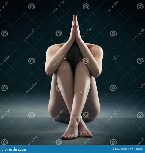 Balanced Beauty Shot Of A Nude Woman Sitting With Her Legs Crossed And Her Arm Stock Photo