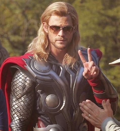 A Man Dressed As Thor Is Giving The Peace Sign With His Hand And