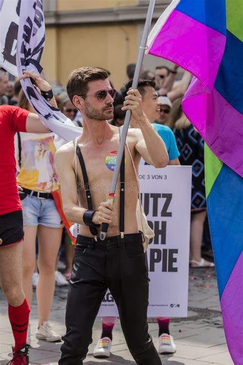 Muscled Handsome Man Holding A Large Rainbow Flag Attending The Gay