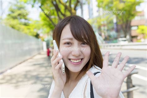 スマホを持つ若い女性 待ち合わせ 手を振る 写真素材 5021008 フォトライブラリー Photolibrary