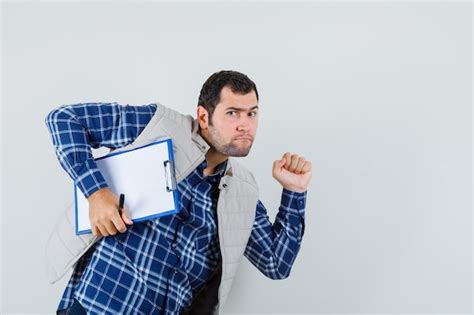 Jovem Macho Segurando A Prancheta Enquanto Se Apressa Em Camisa