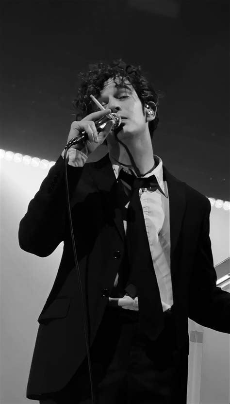 A Man In A Tuxedo Singing Into A Microphone