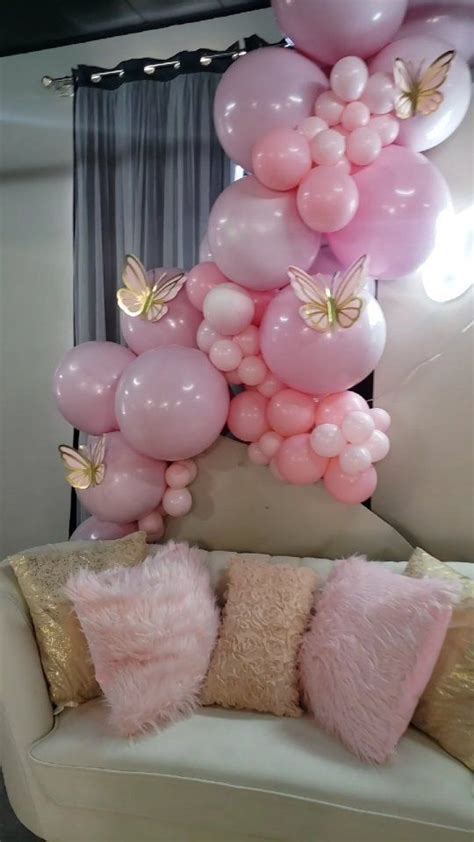 Pink Balloons Are Hanging From The Ceiling Above A White Couch With