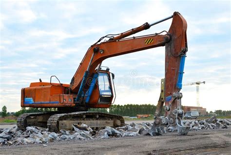 Excavator With Hydraulic Shears Breaks Asphalt On A Construction Site