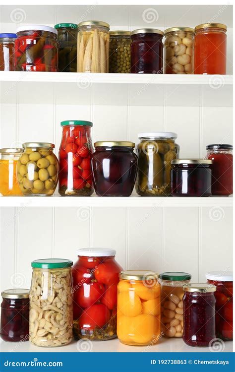 Jars Of Pickled Fruits And Vegetables On White Shelves Stock Image