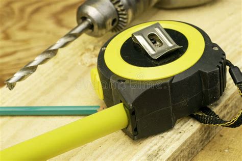 Measuring Tape Pencil And Electric Drill With Drill On Board