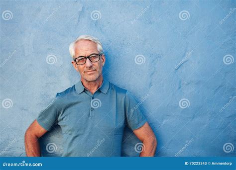Mature Man Standing Against A Blue Wall Stock Image Image Of Attitude Background
