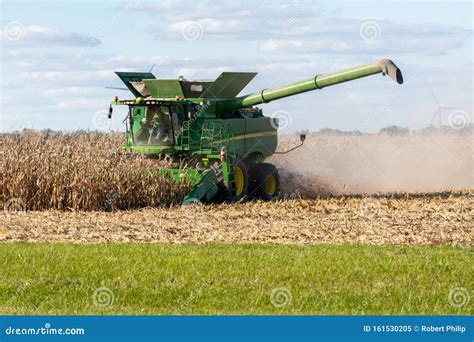 A Farmer Combining A Field Of Corn In His John Deere Combine Harvester