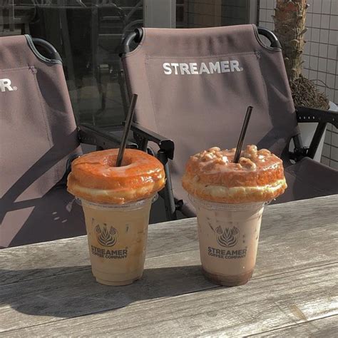 Two Iced Coffees Sitting On Top Of A Wooden Table Next To Eachother