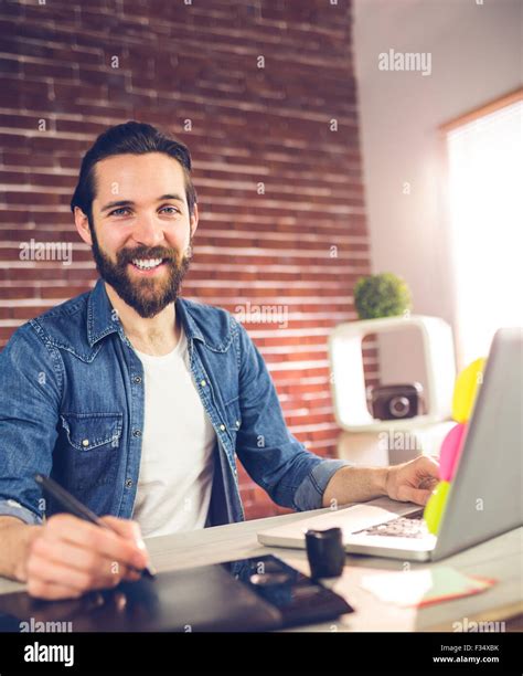 Portrait Of Smiling Businessman Using Graphic Tablet And Laptop Stock