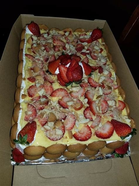 A Cake In A Box With Strawberries And Nuts On The Top Is Ready To Be Eaten