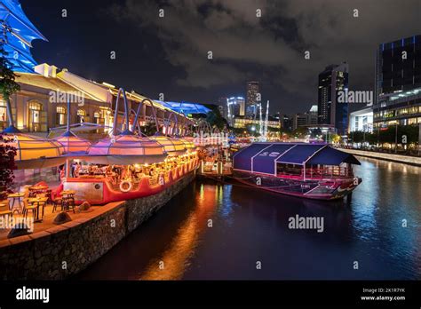 Clarke Quay on Singapore River illuminated by coloured lights with ...