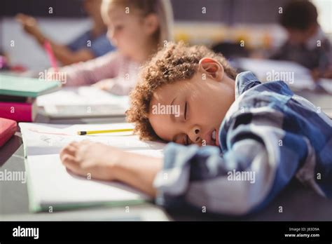 Tired Schoolboy Sleeping In Classroom At School Stock Photo Alamy