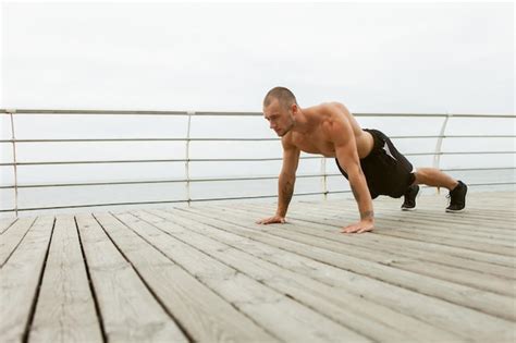 Premium Photo Handsome Muscular Man With Naked Torso Doing Push Up Exercise On The Beach
