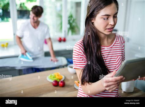 Brunette Using Tablet In Kitchen Stock Photo Alamy