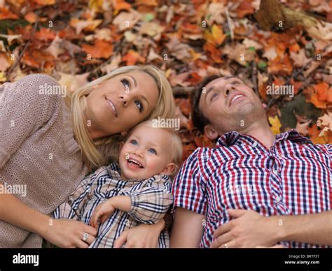 Happy Smiling Young Parents And A Two Year Old Girl Lying On Colorful