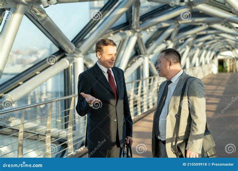 Two Mature Male Delegates In Elegant Suits Discussing Terms Of