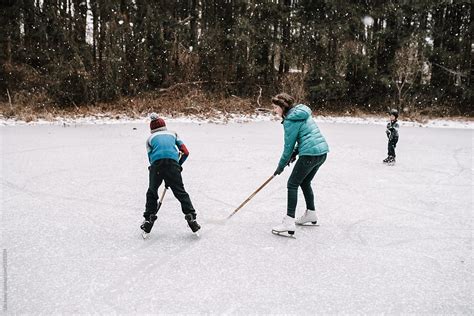 Kids Playing Hockey On Frozen Pond By Stocksy Contributor Léa Jones