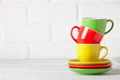 Tazas Coloridas En El Fondo Blanco De Una Pared De Ladrillo Fondo Con