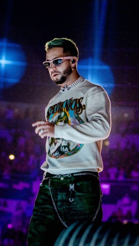 A Man Standing On Top Of A Stage Wearing Sunglasses