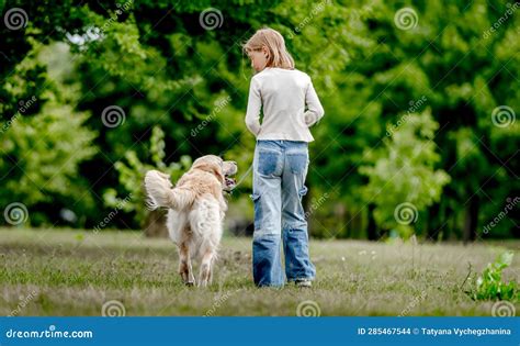 Chica Con Perro Recuperador De Oro En La Naturaleza Foto De Archivo