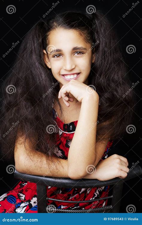 Pretty Girl Sitting On A Chair Smiling And Looking At The Camera Stock