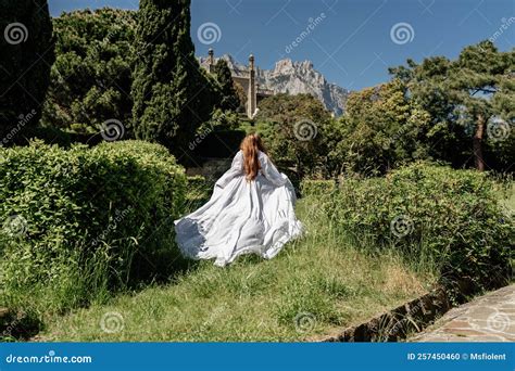 A Beautiful Woman With Long Brown Hair And Long White Dress Stay Along