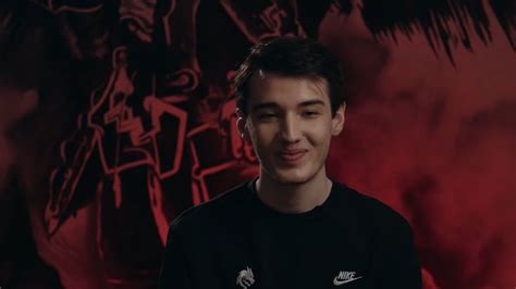 A Man Standing In Front Of A Red Background