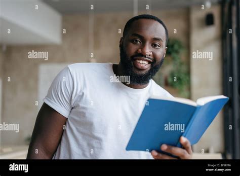 Portrait Of Happy African American Man Reading A Book Smiling Student