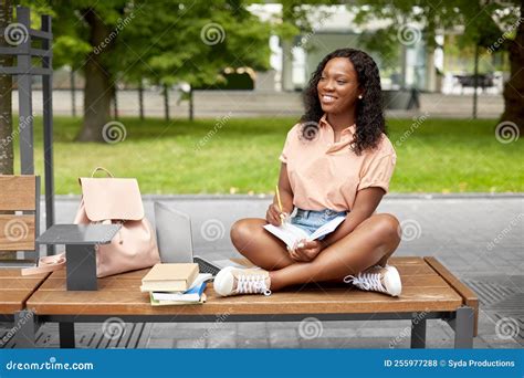 Une étudiante Africaine Heureuse Qui Prend Des Notes Dans Un Livre