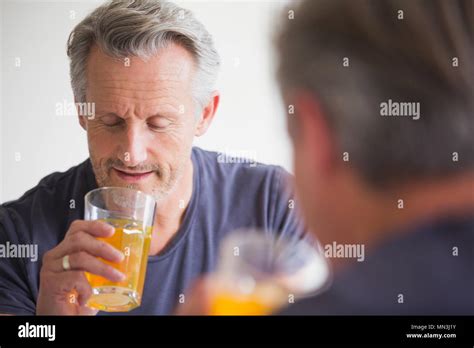 Mature Man Drinking Juice At Mirror Stock Photo Alamy
