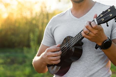 Young Man Playing Ukulele In Park Premium Photo